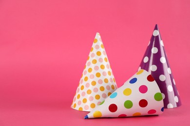 Bright party hats on pink background. Space for text