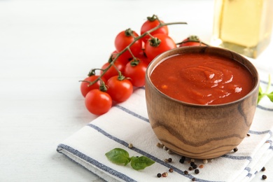 Photo of Bowl of tomato sauce on white table, space for text