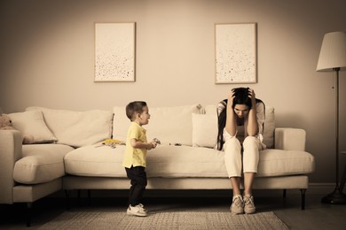 Depressed single mother with child in living room, color toned