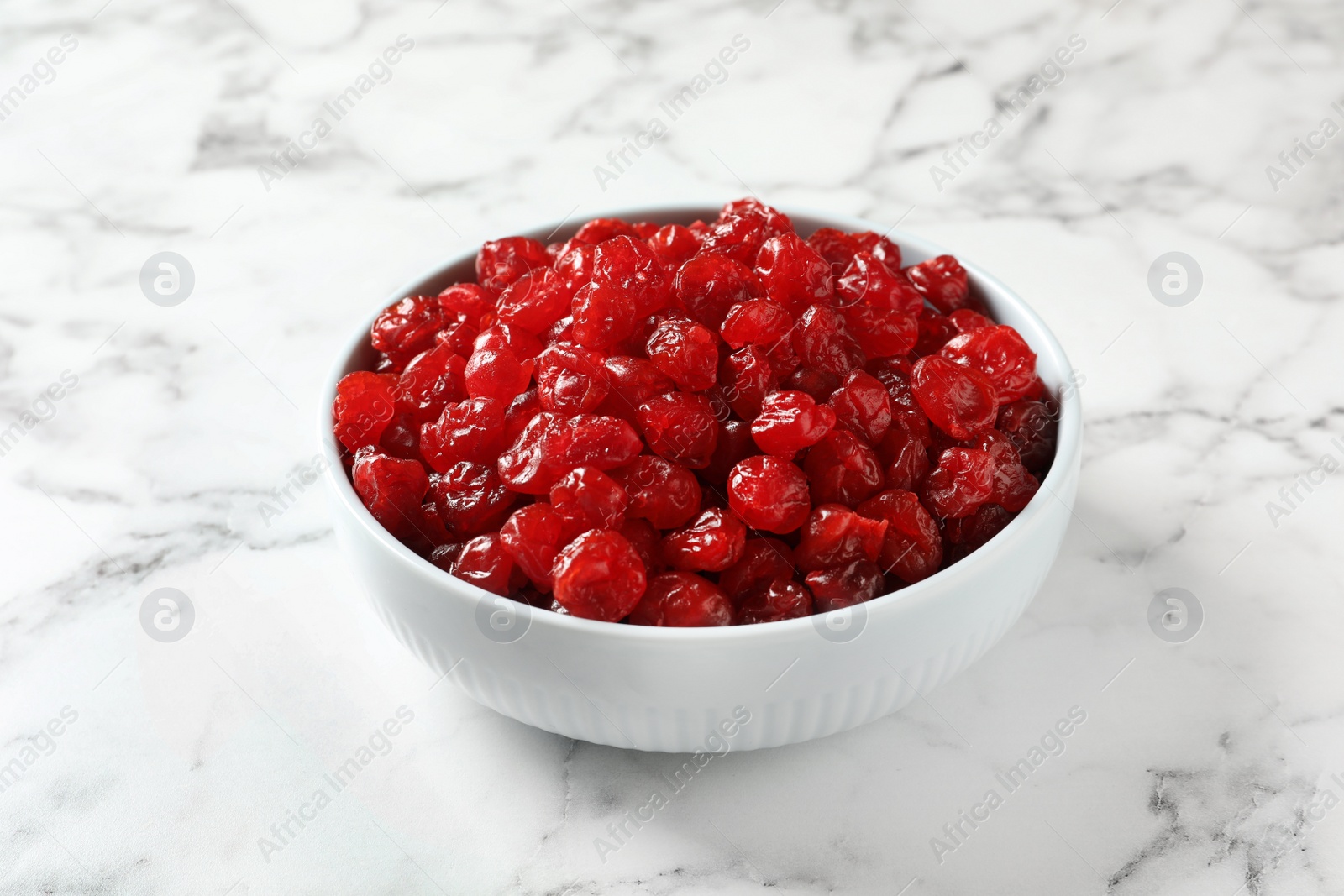 Photo of Bowl of sweet cherries on marble background. Dried fruit as healthy snack