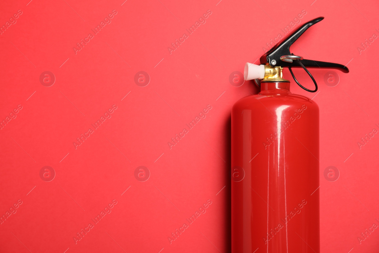 Photo of One fire extinguisher on red background, top view. Space for text