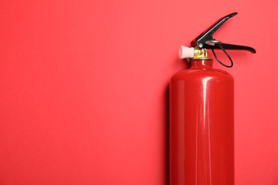 Photo of One fire extinguisher on red background, top view. Space for text