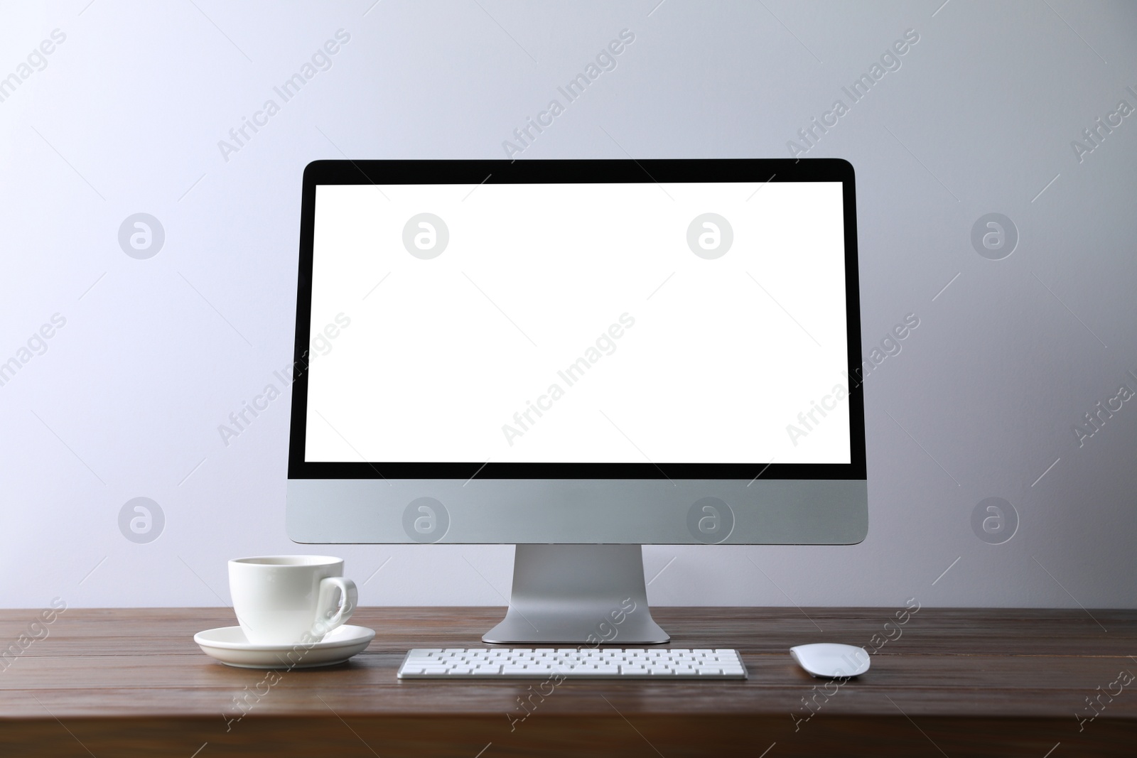 Photo of Workplace with modern computer monitor, keyboard and mouse on wooden table. Mockup for design