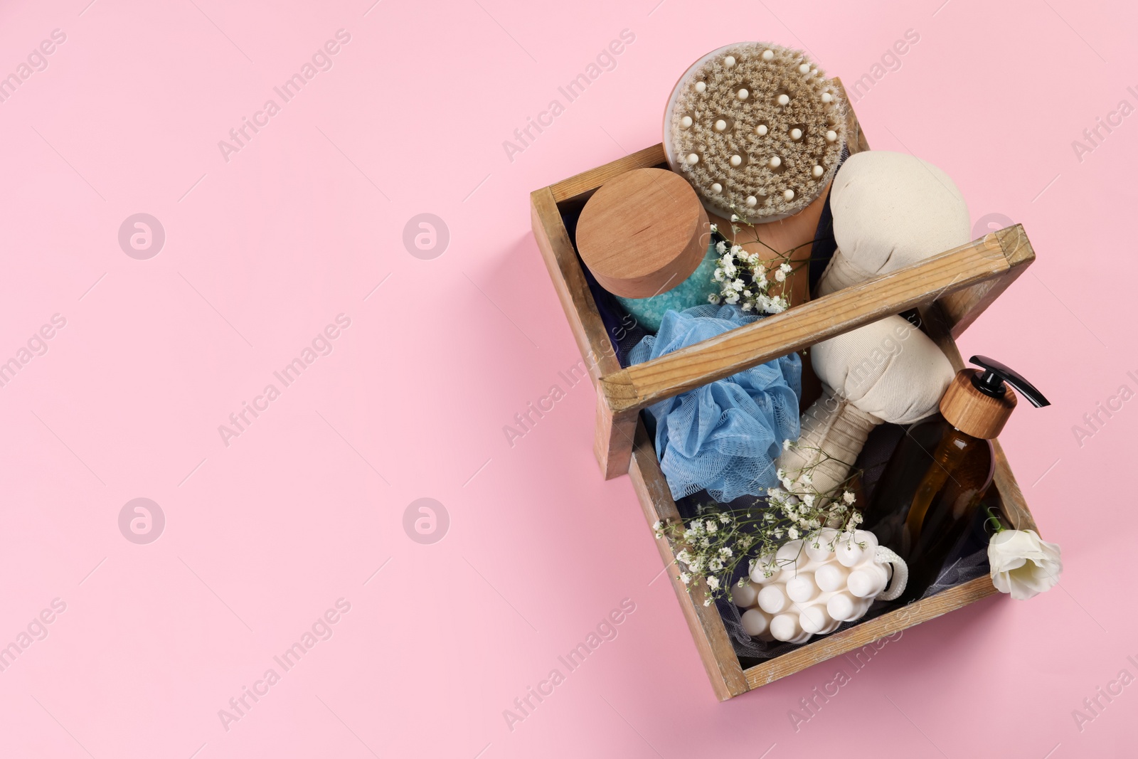 Photo of Spa gift set with different products in crate on pink background, top view. Space for text