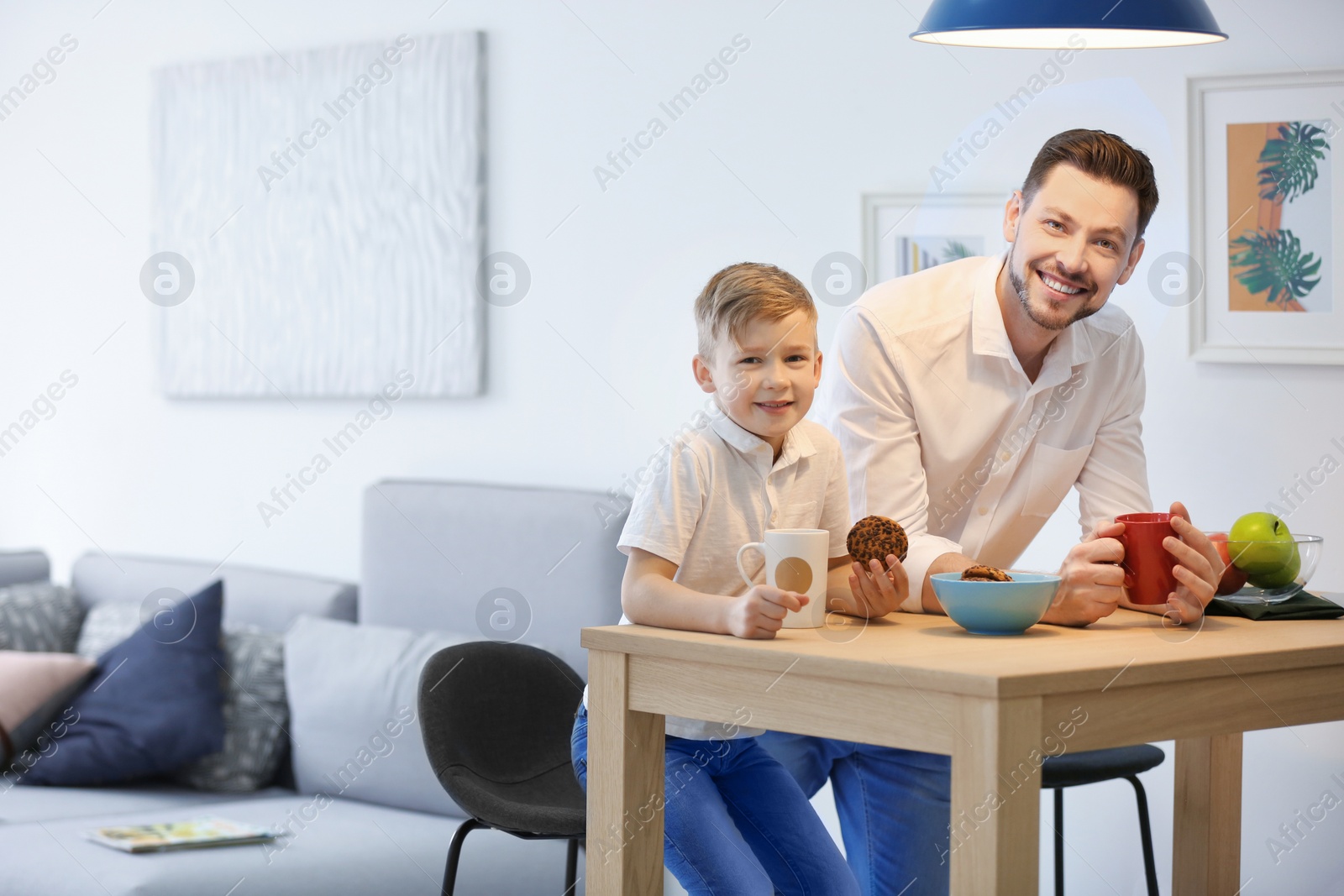 Photo of Little boy and his dad having breakfast at home