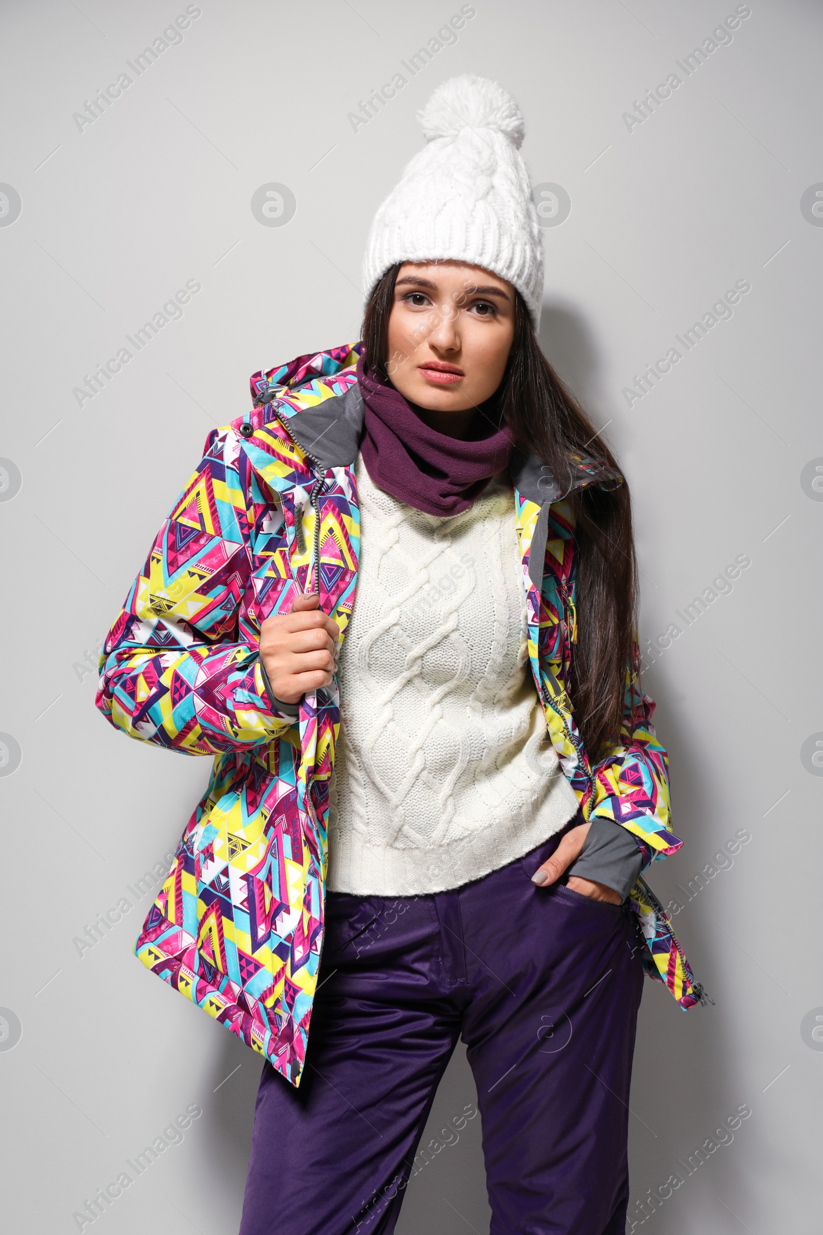 Photo of Woman wearing stylish winter sport clothes on light grey background