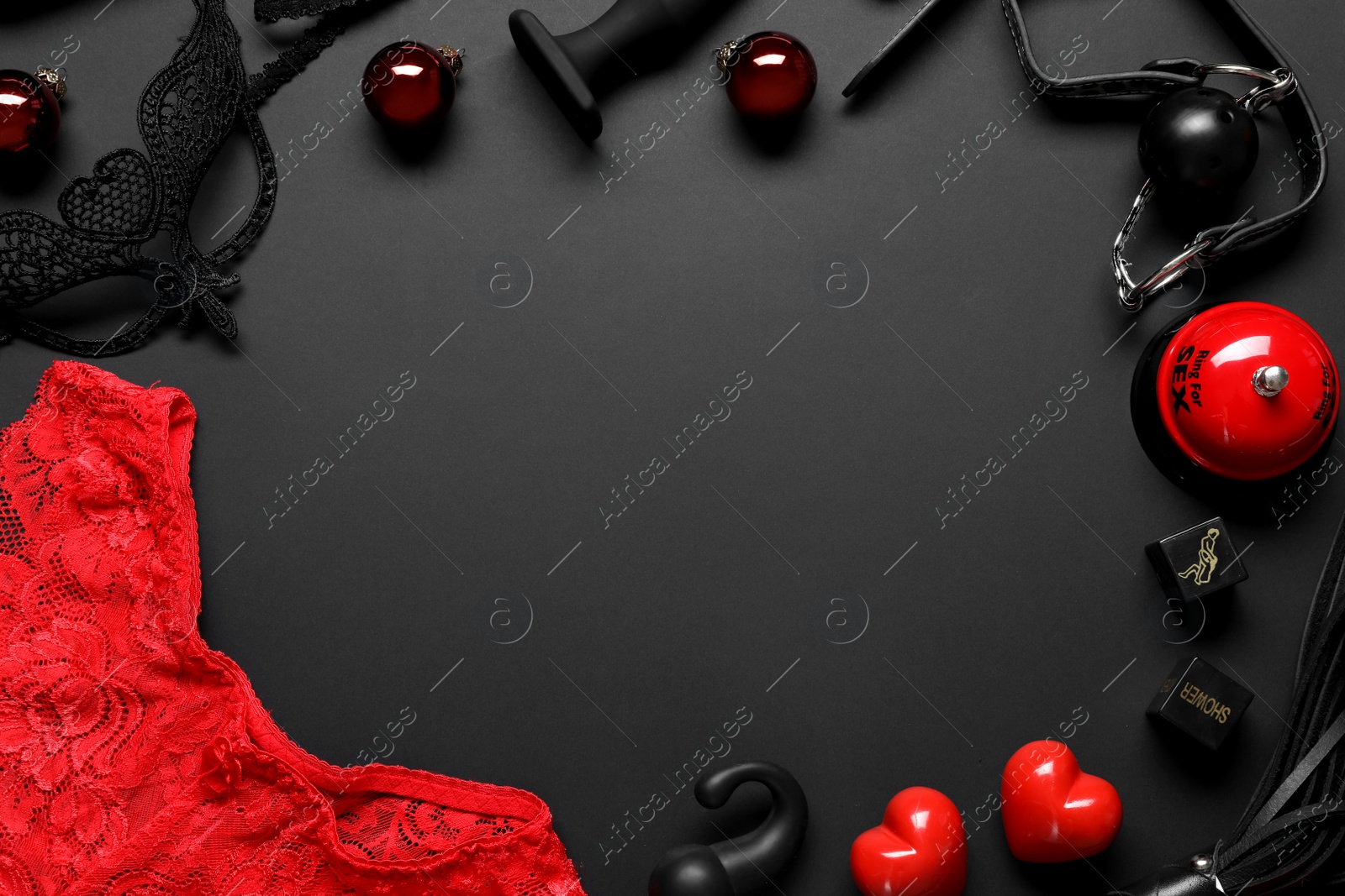 Photo of Frame made with different sex toys and Christmas balls on black background, flat lay. Space for text