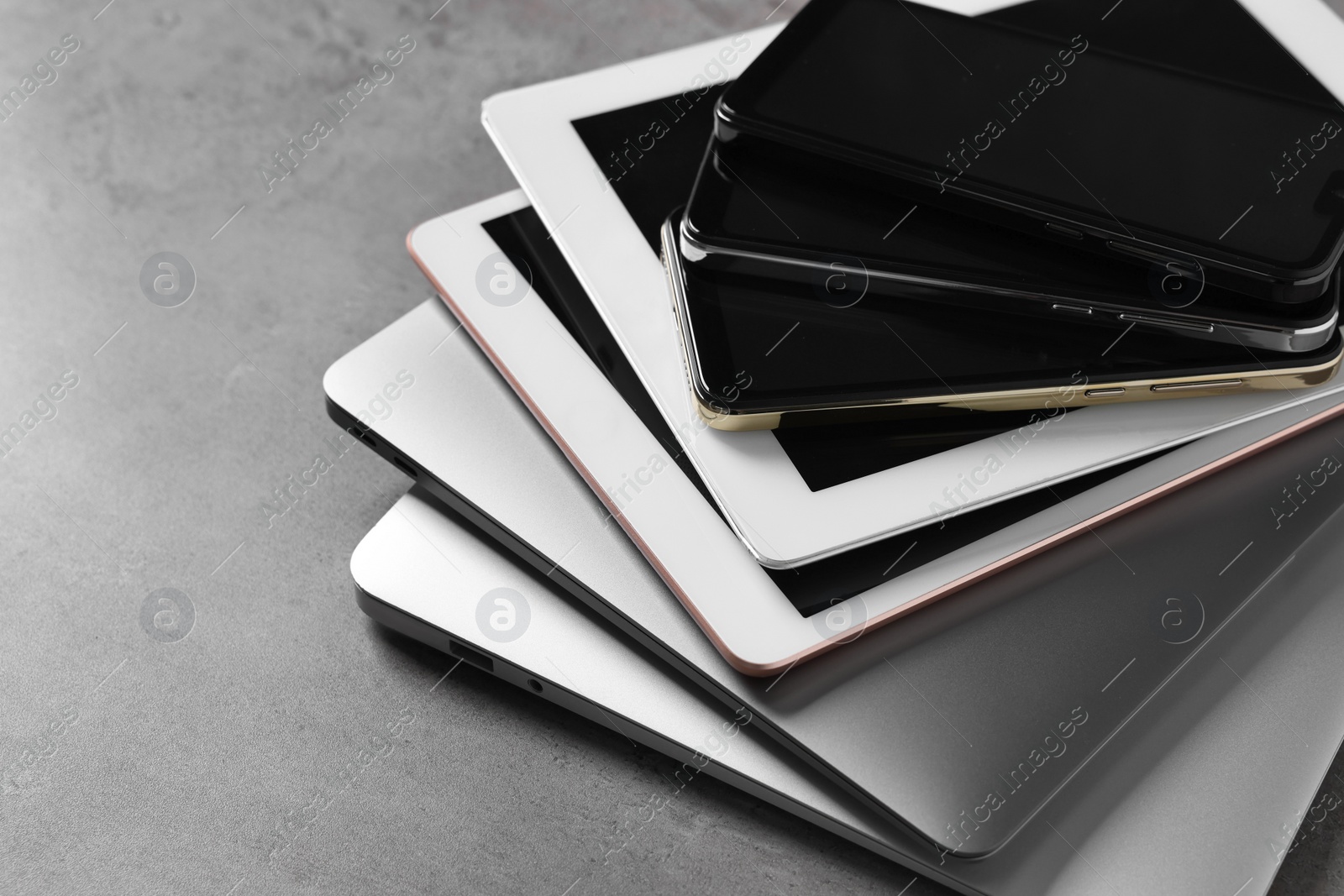 Photo of Many different modern gadgets on grey table, closeup