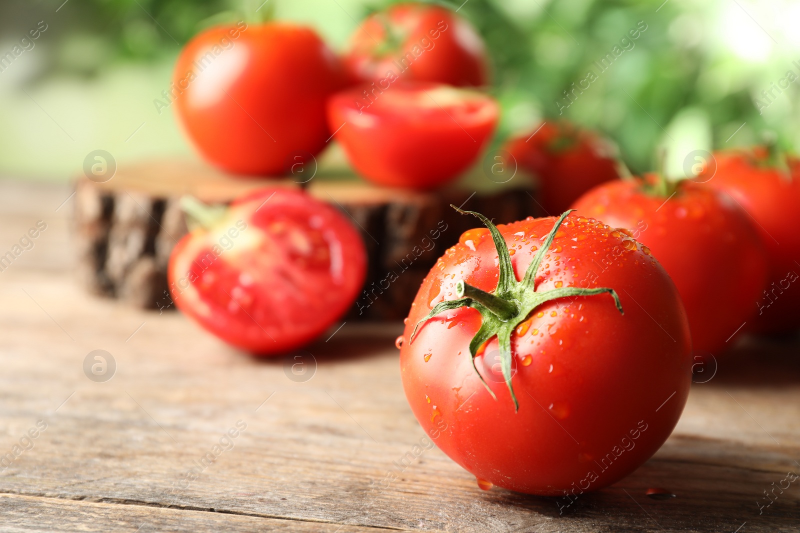 Photo of Fresh ripe tomatoes on wooden table, closeup