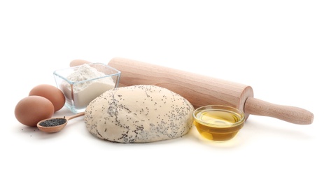 Photo of Raw dough with poppy seeds, rolling pin and ingredients on white background