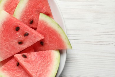 Photo of Delicious fresh watermelon slices on white wooden table, top view. Space for text