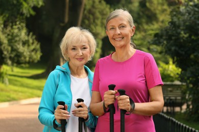 Photo of Senior women with Nordic walking poles outdoors