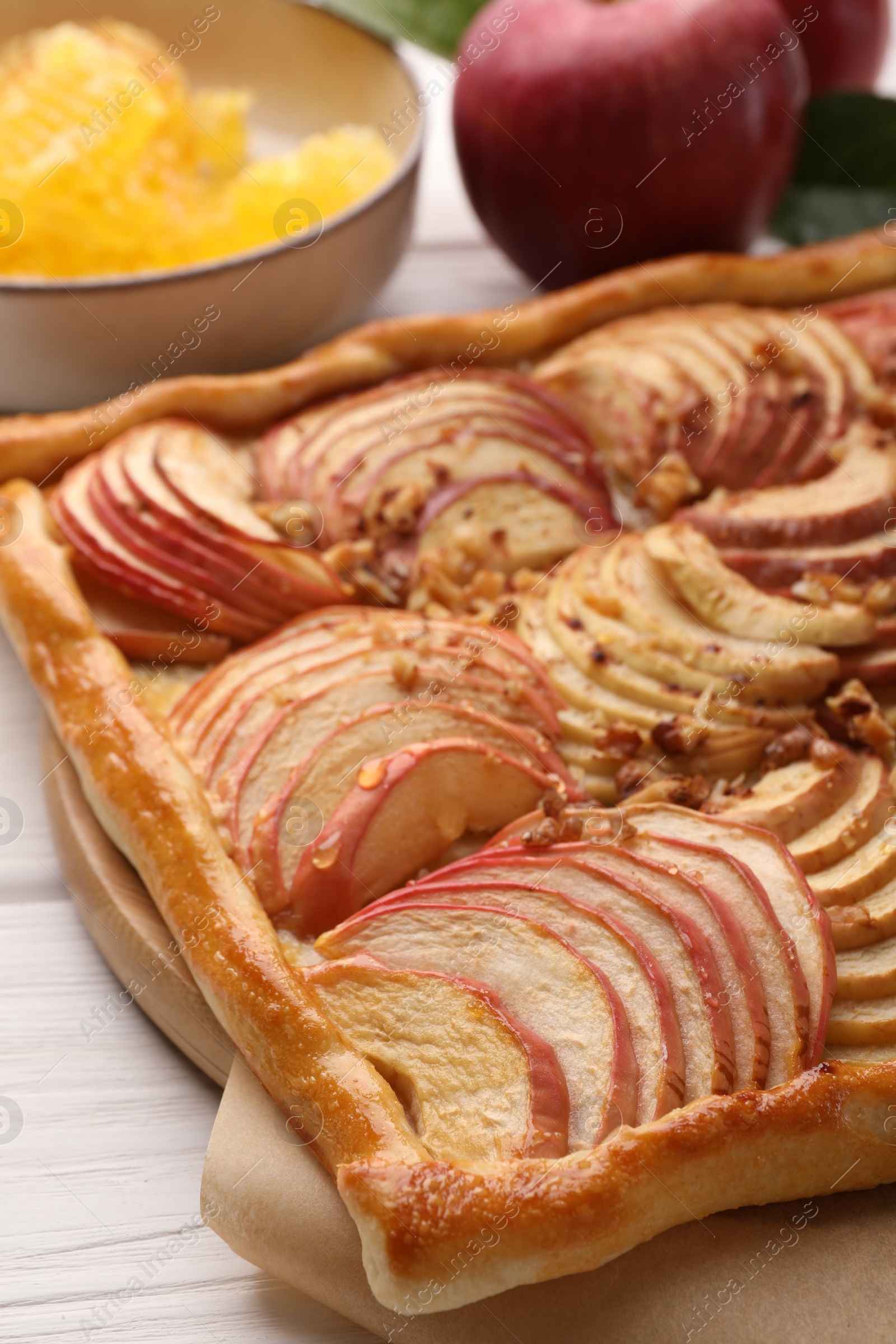 Photo of Tasty fresh apple galette and ingredients on white wooden table, closeup