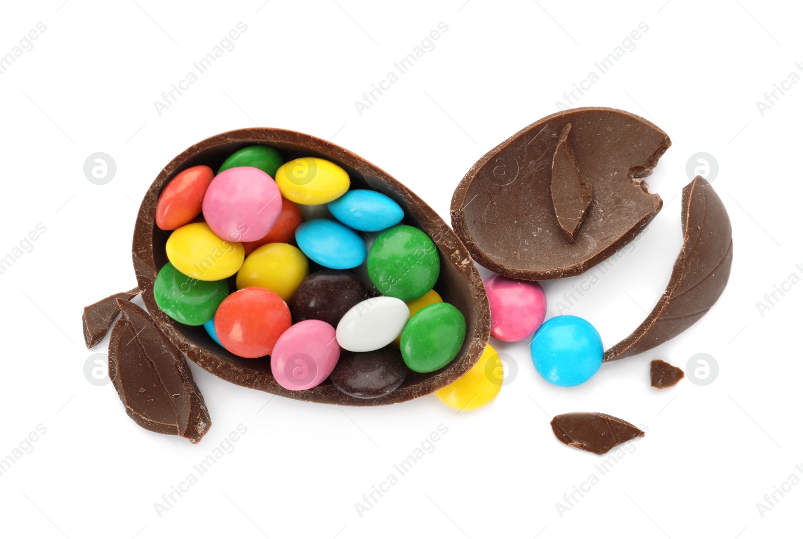 Photo of Broken chocolate egg with colorful candies on white background