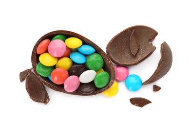 Photo of Broken chocolate egg with colorful candies on white background