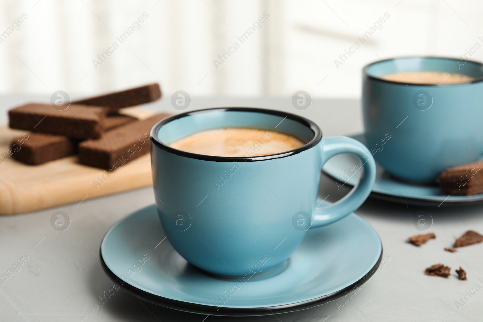 Photo of Delicious coffee and wafers for breakfast on grey table