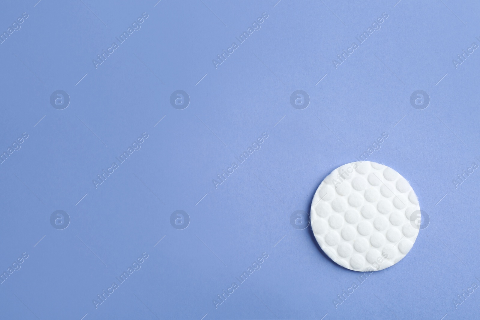 Photo of Cotton pad on color background, top view. Space for text