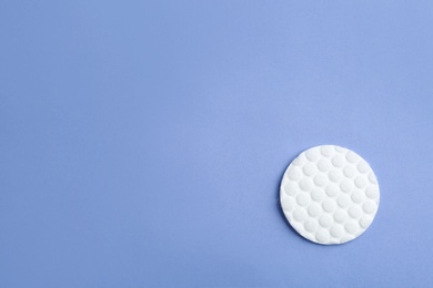 Photo of Cotton pad on color background, top view. Space for text