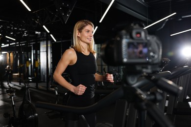 Fitness trainer recording online classes in gym