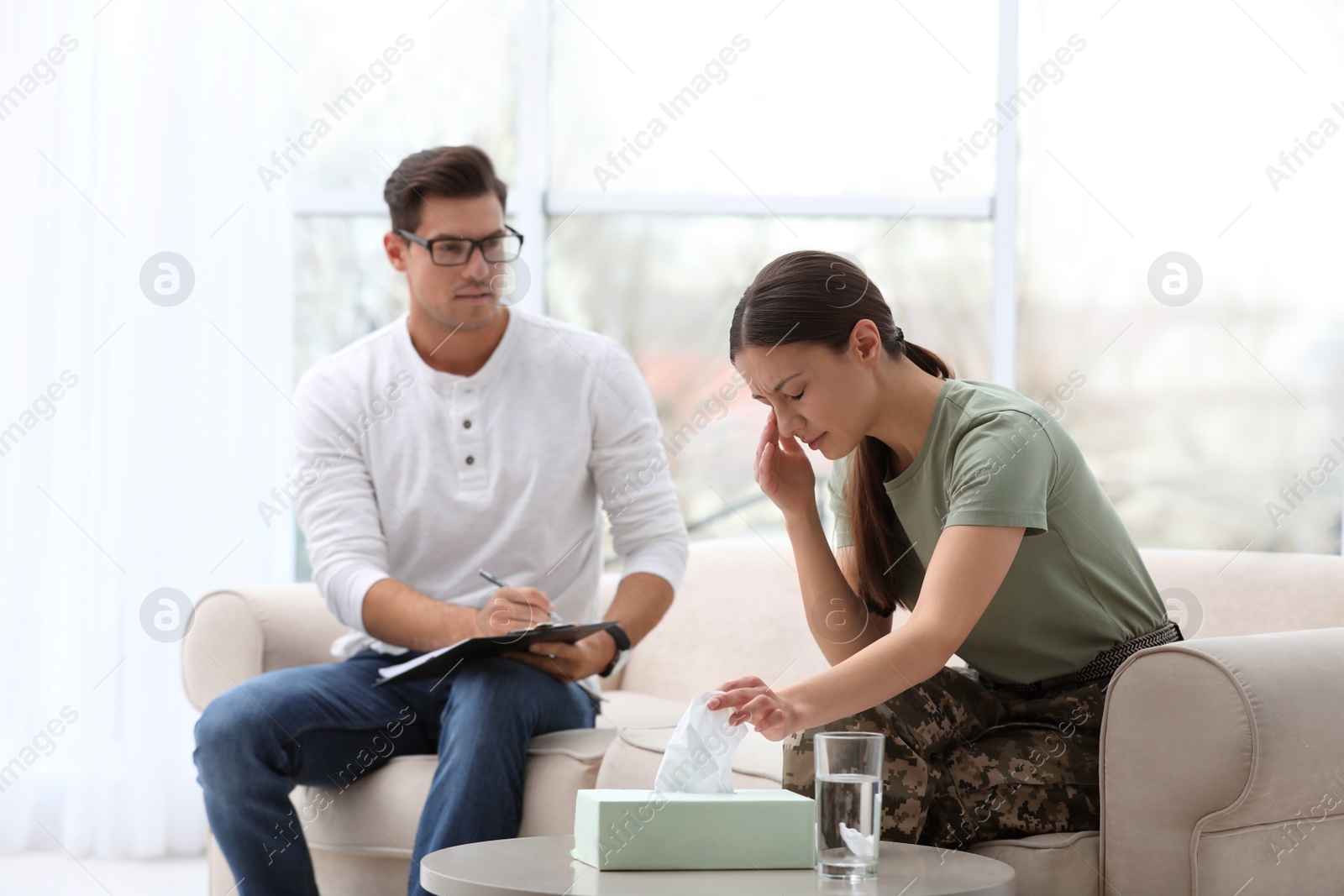 Photo of Psychotherapist working with female military officer in office