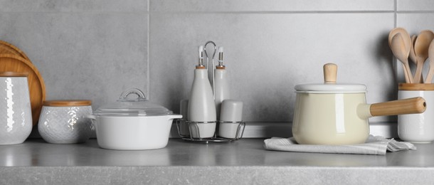 Image of Set of different cooking utensils on grey countertop in kitchen, banner design