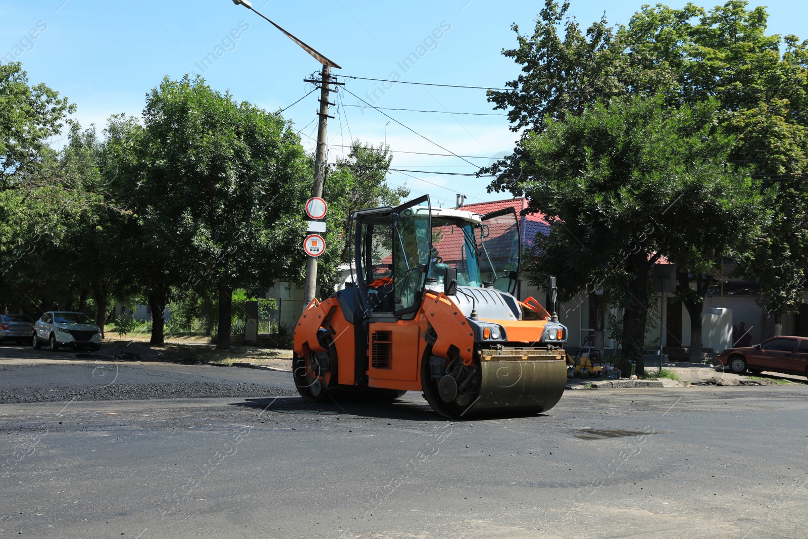 Photo of Roller working on city street. Road repairing