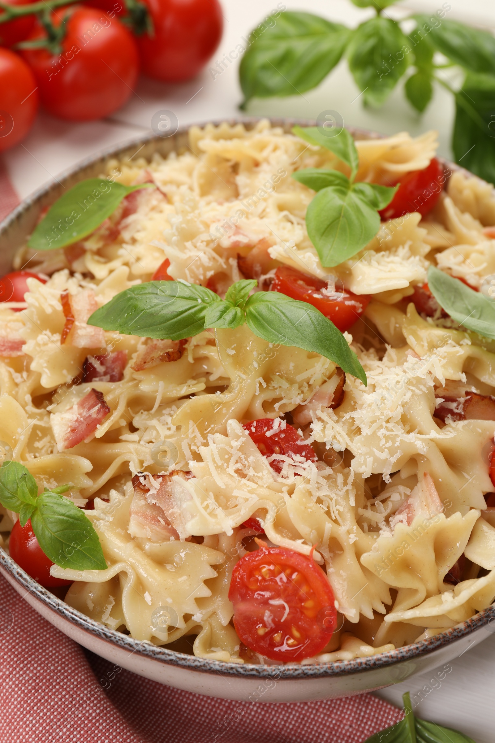 Photo of Plate of delicious pasta with tomatoes, basil and parmesan cheese on table, closeup