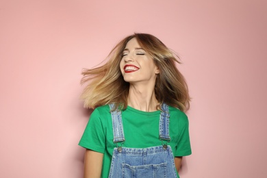 Photo of Beautiful young woman with healthy long blonde hair on color background