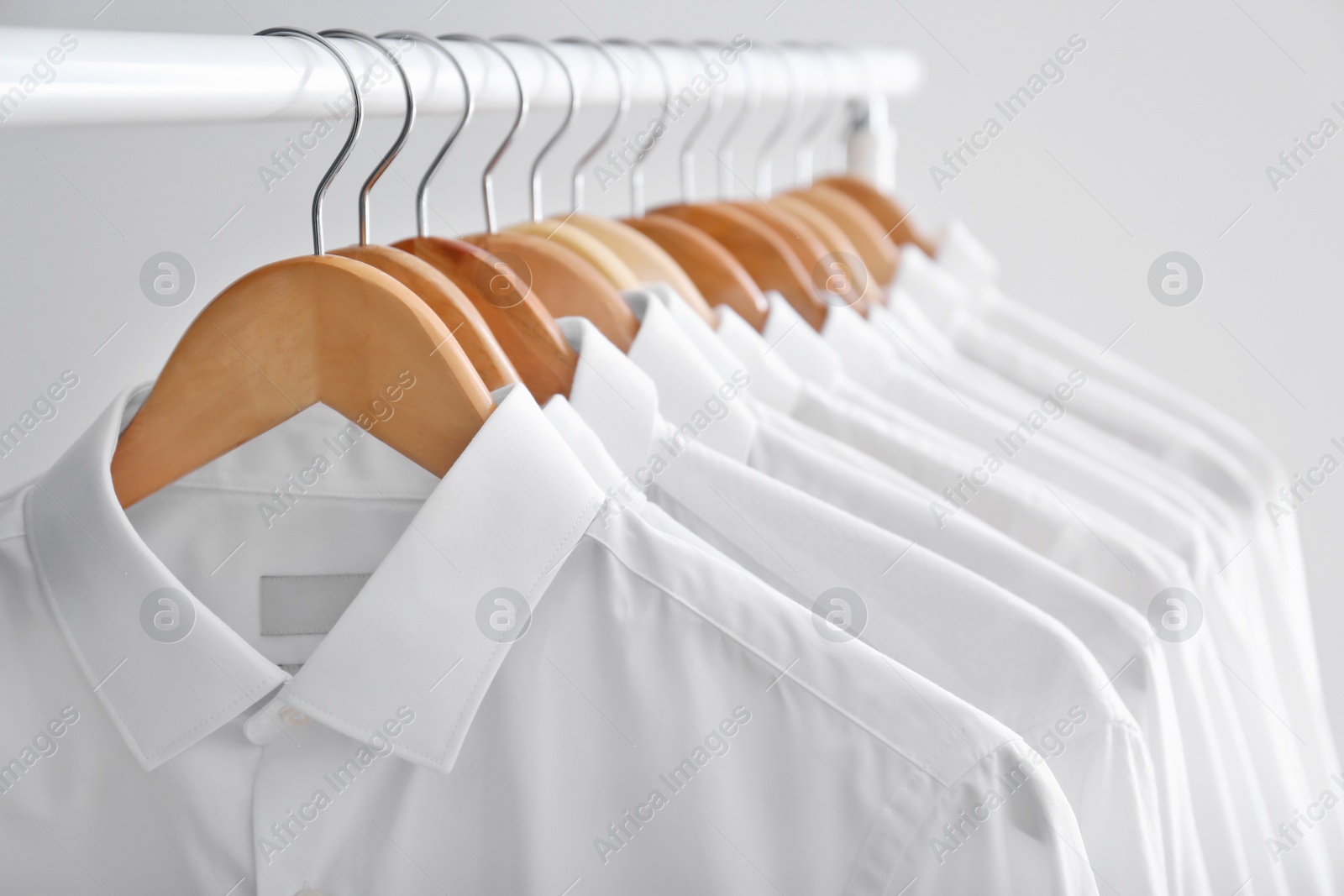 Photo of Rack with clean clothes on hangers after dry-cleaning