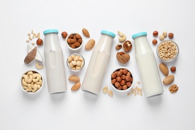 Photo of Vegan milk and different nuts on white background, flat lay