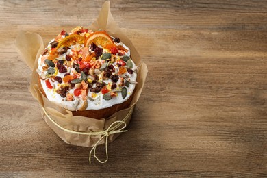 Photo of Traditional Easter cake with dried fruits on wooden table, space for text