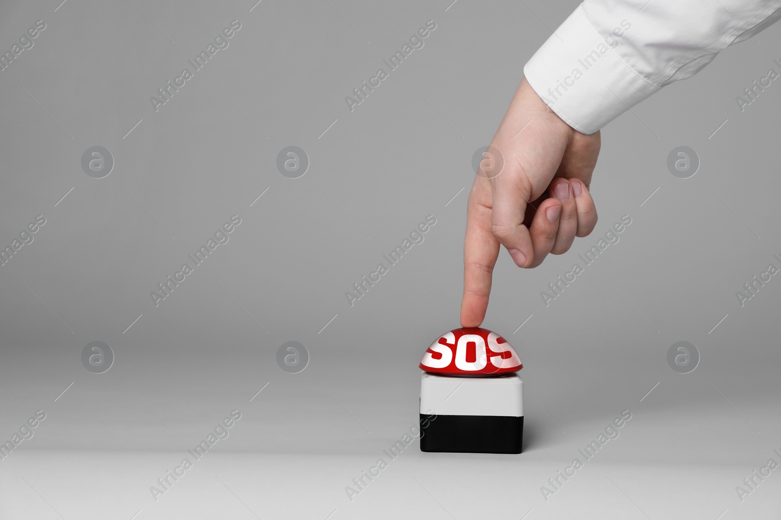 Image of Man pressing red SOS button at white background, closeup