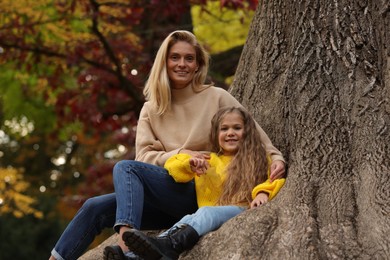 Happy mother spending time together with her daughter in autumn park