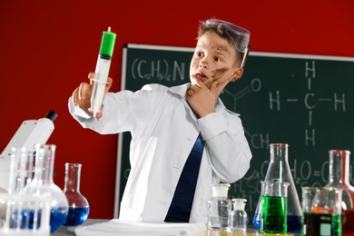 Child doing chemical research in laboratory. Dangerous experiment