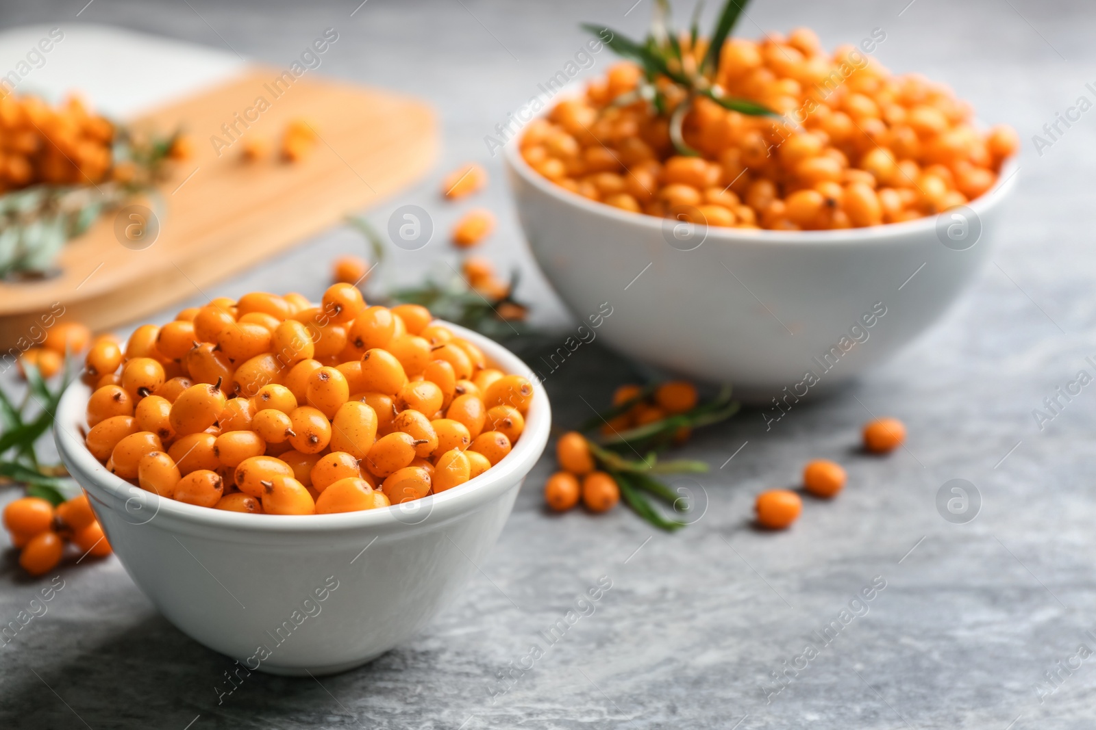 Photo of Fresh ripe sea buckthorn in bowl on grey table