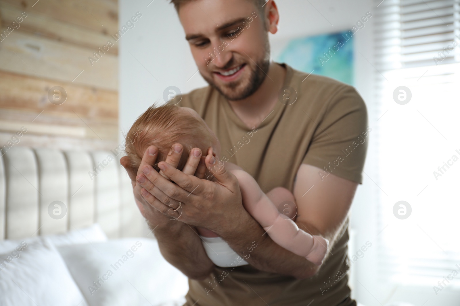 Photo of Father with his newborn son at home