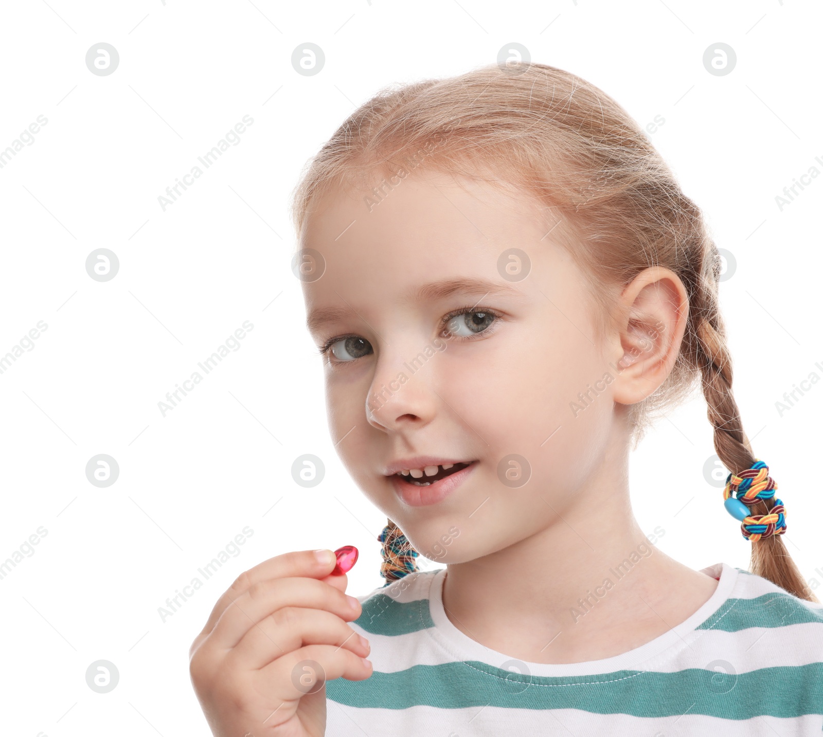 Photo of Little girl taking vitamin pill on white background