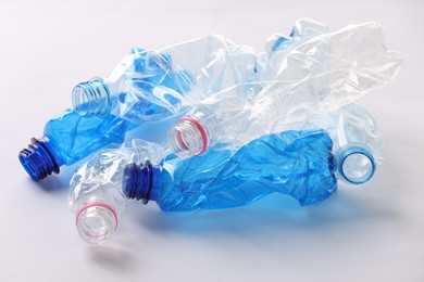 Photo of Crumpled disposable plastic bottles on white background