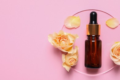 Photo of Bottle of cosmetic serum, flowers and petals on pink background, flat lay. Space for text