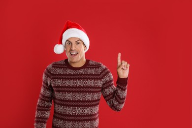 Excited man in Santa hat on red background. Christmas countdown