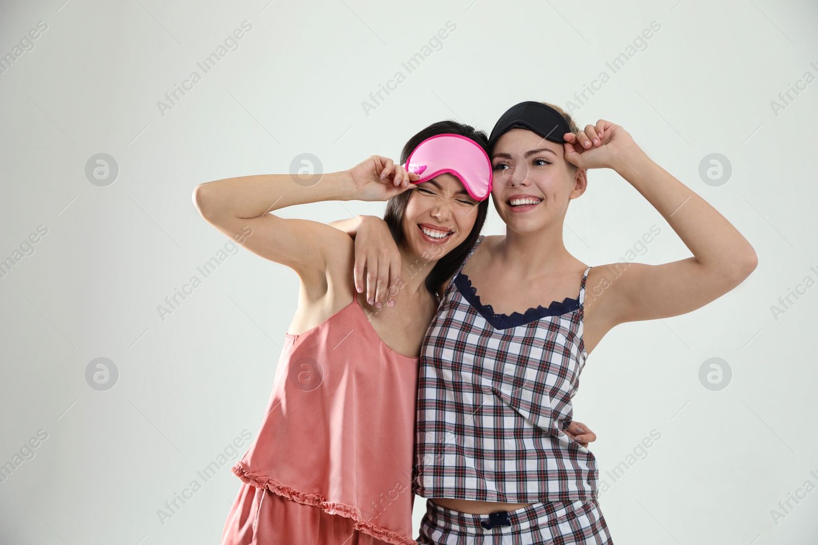 Photo of Beautiful women in pajamas on light grey background. Bedtime