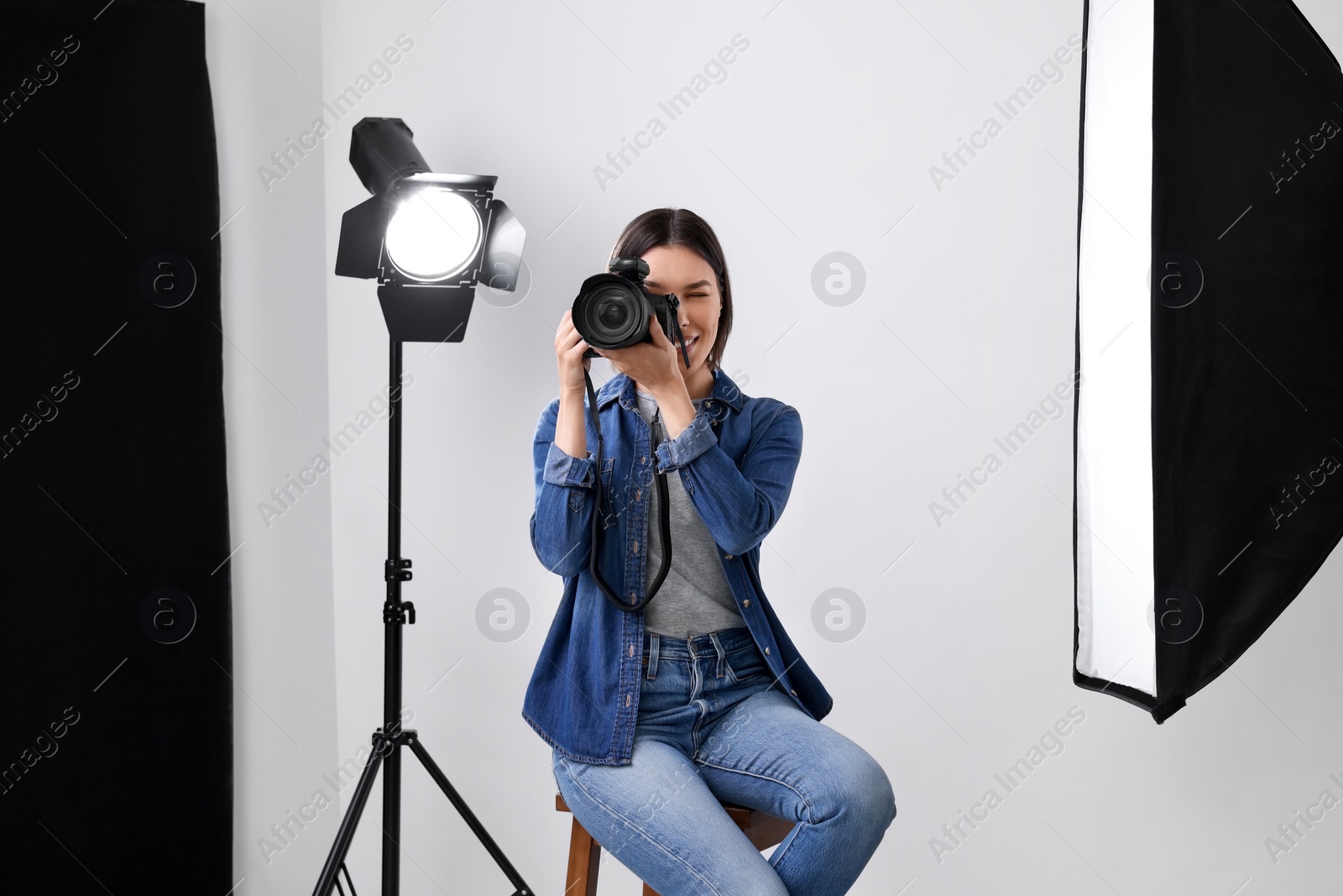 Photo of Professional photographer taking picture in modern photo studio