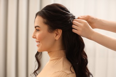 Photo of Hair styling. Professional hairdresser working with smiling client indoors, closeup