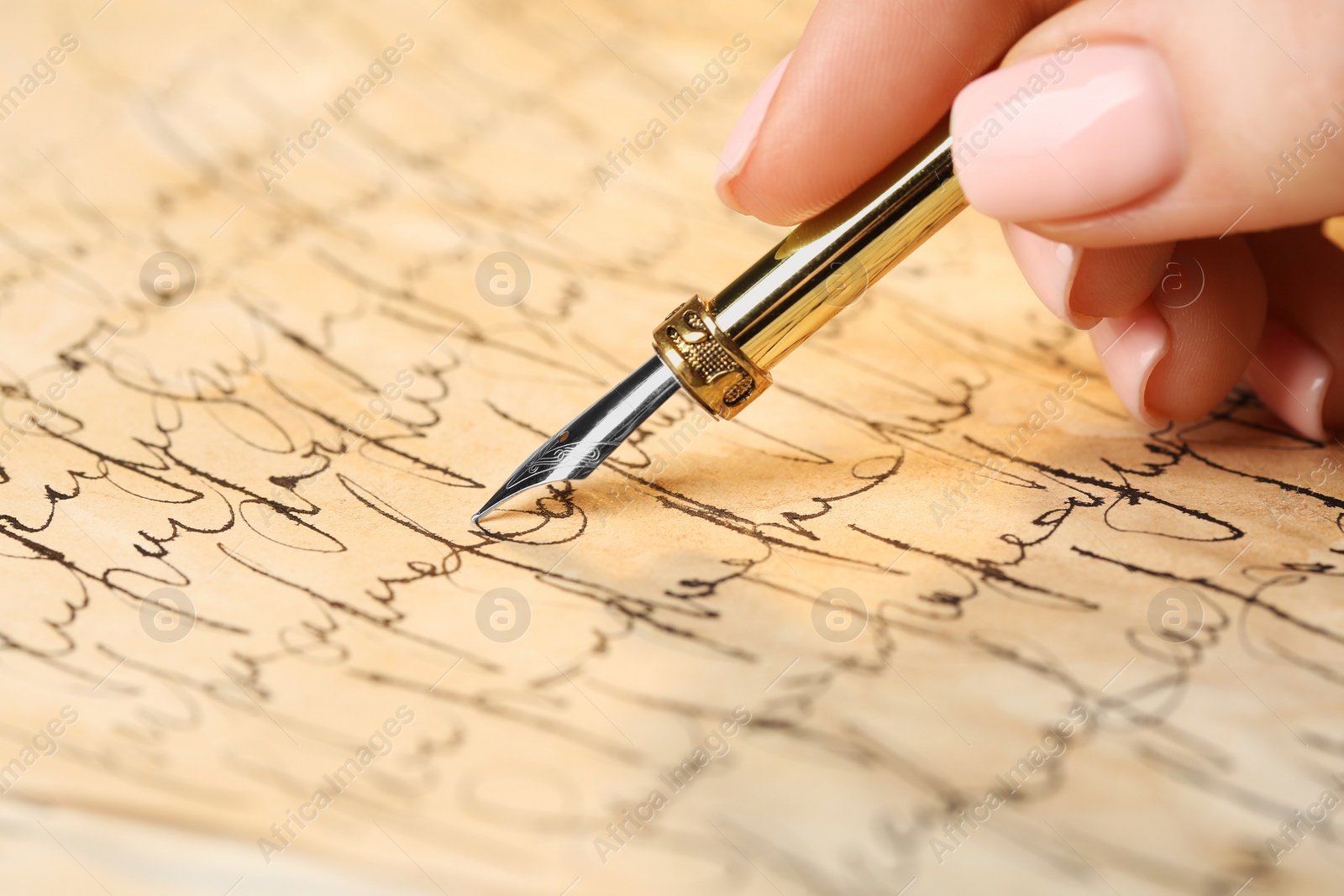 Photo of Woman writing letter with fountain pen, closeup