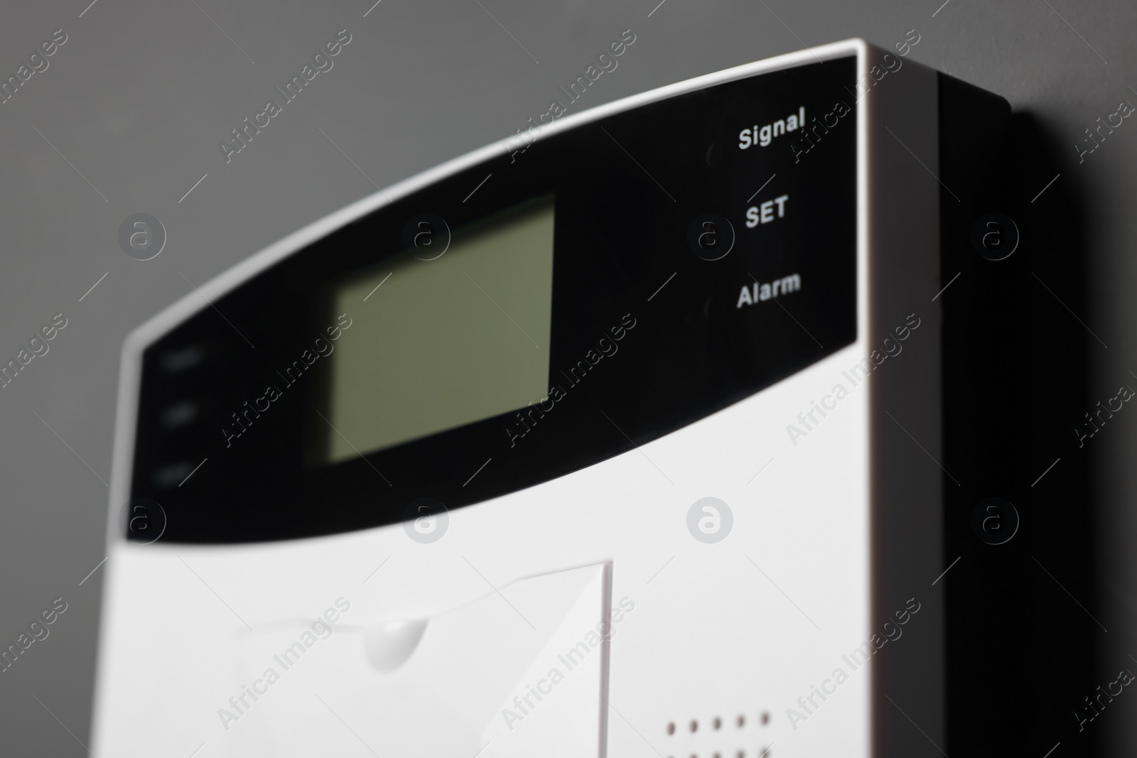 Photo of Home security alarm system on gray wall, closeup