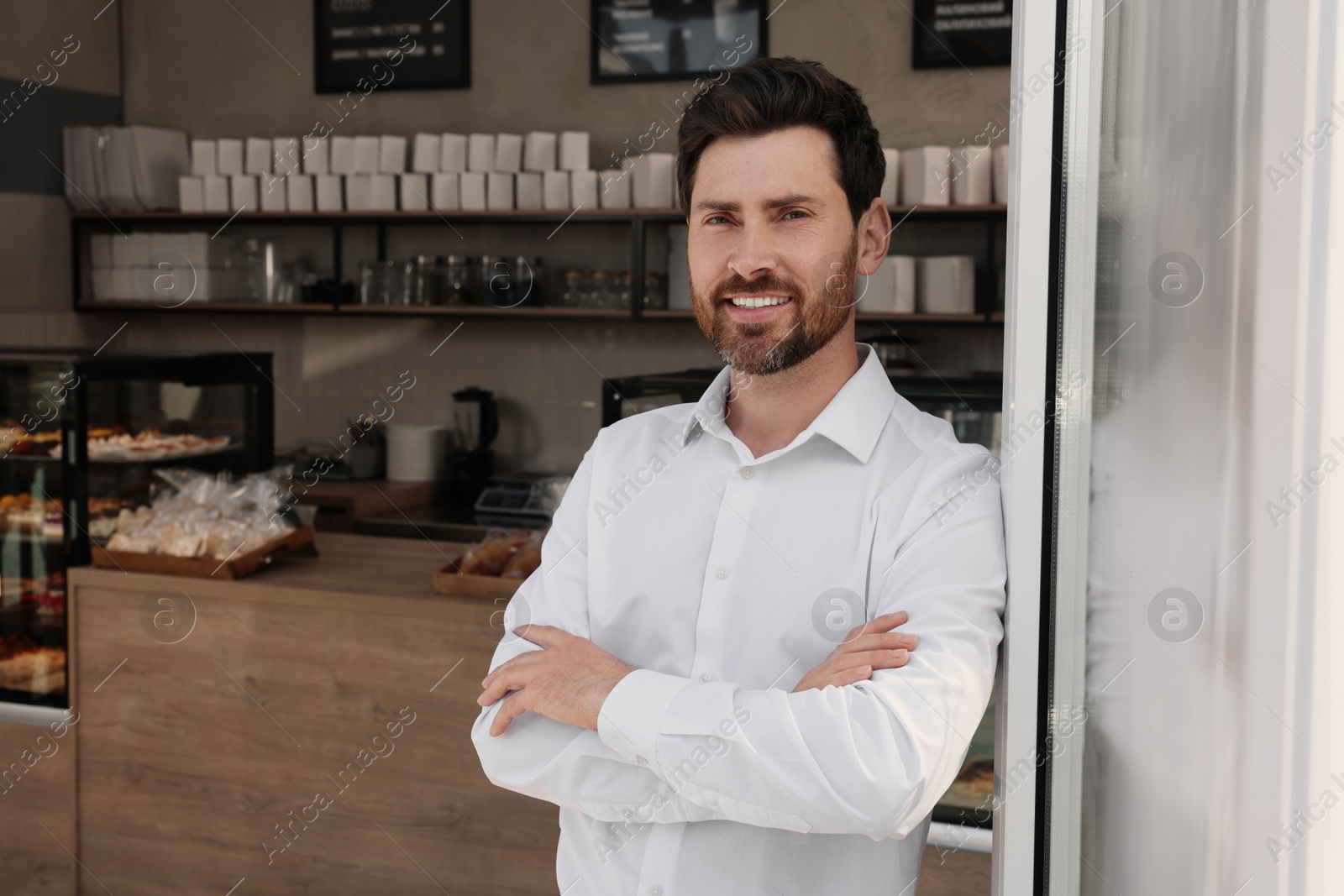 Photo of Happy business owner in bakery shop. Space for text