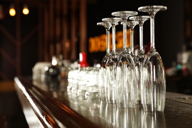 Different empty clean glasses on counter in bar. Space for text