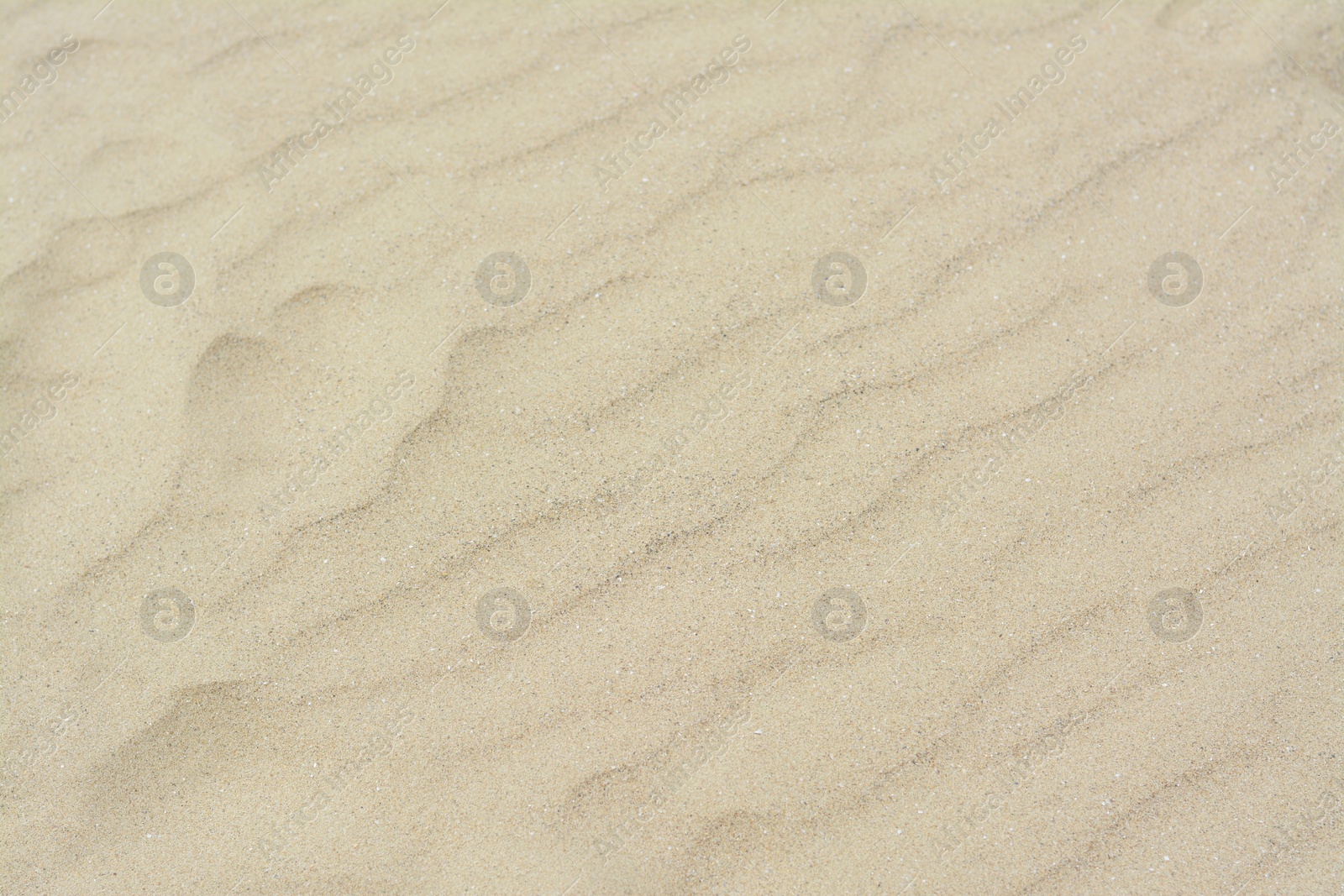 Photo of Dry beach sand with wave pattern as background