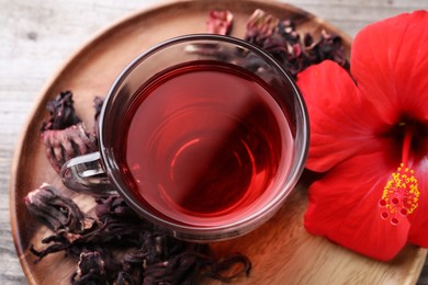 Photo of Delicious hibiscus tea and flowers on table, above view