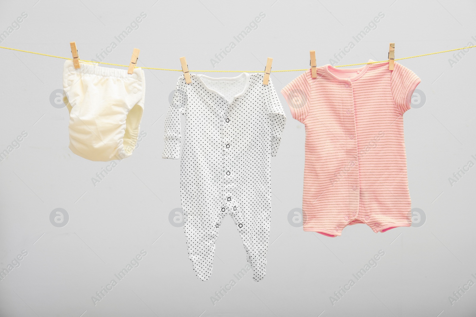 Photo of Children's clothes on laundry line against light background